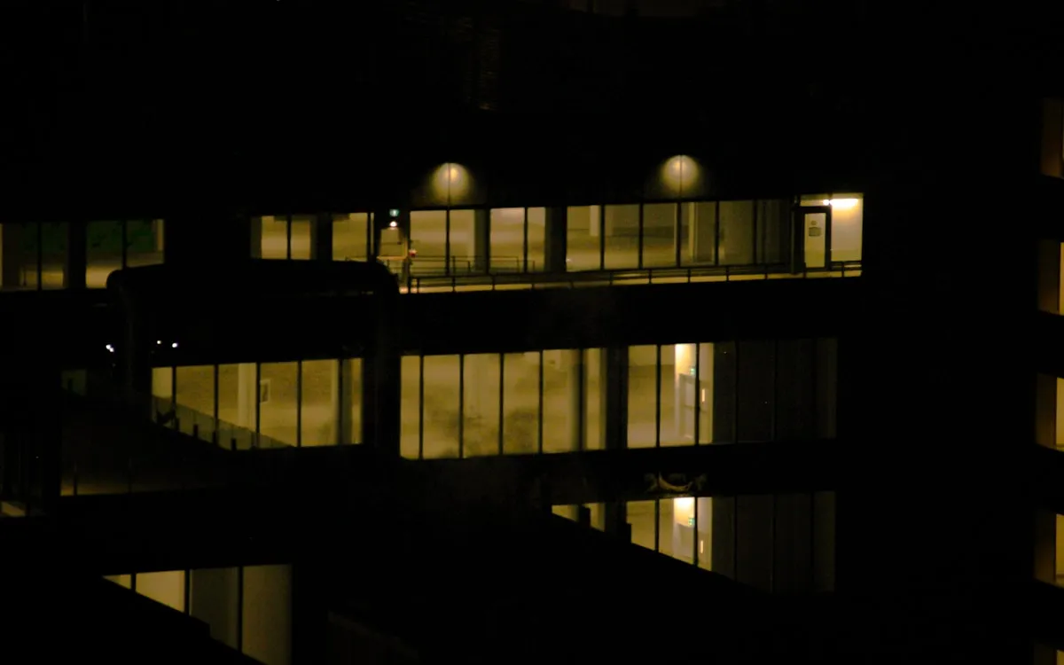 Entrée d’immeuble éclairée par les phares d’un véhicule de patrouille la nuit