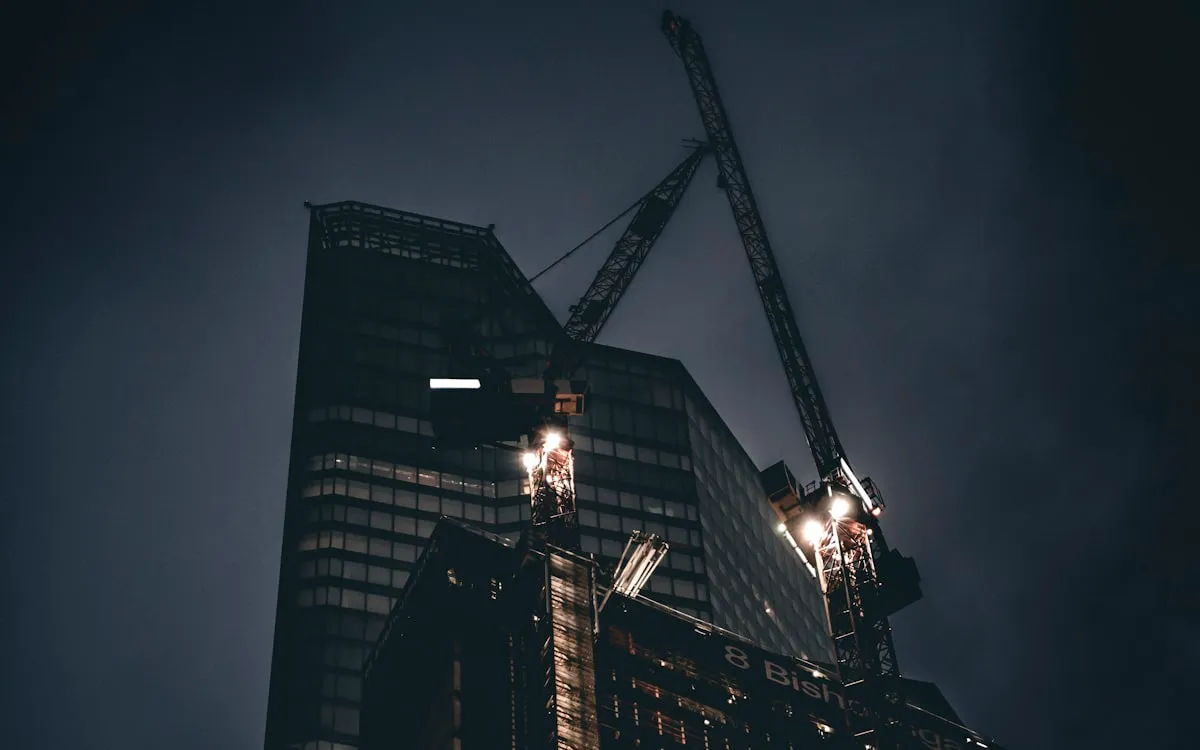 Chantier de construction clôturé sous éclairage temporaire la nuit