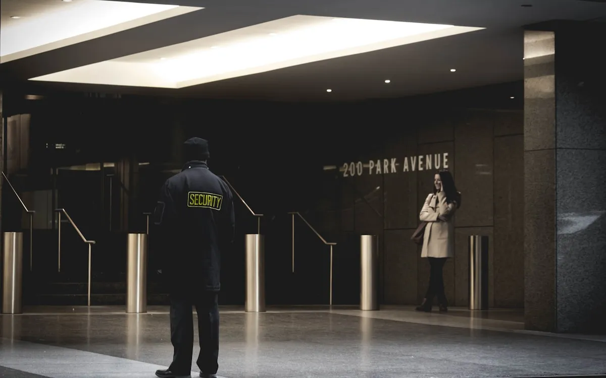 Agent de sécurité en uniforme au poste de contrôle d’accès d’un immeuble